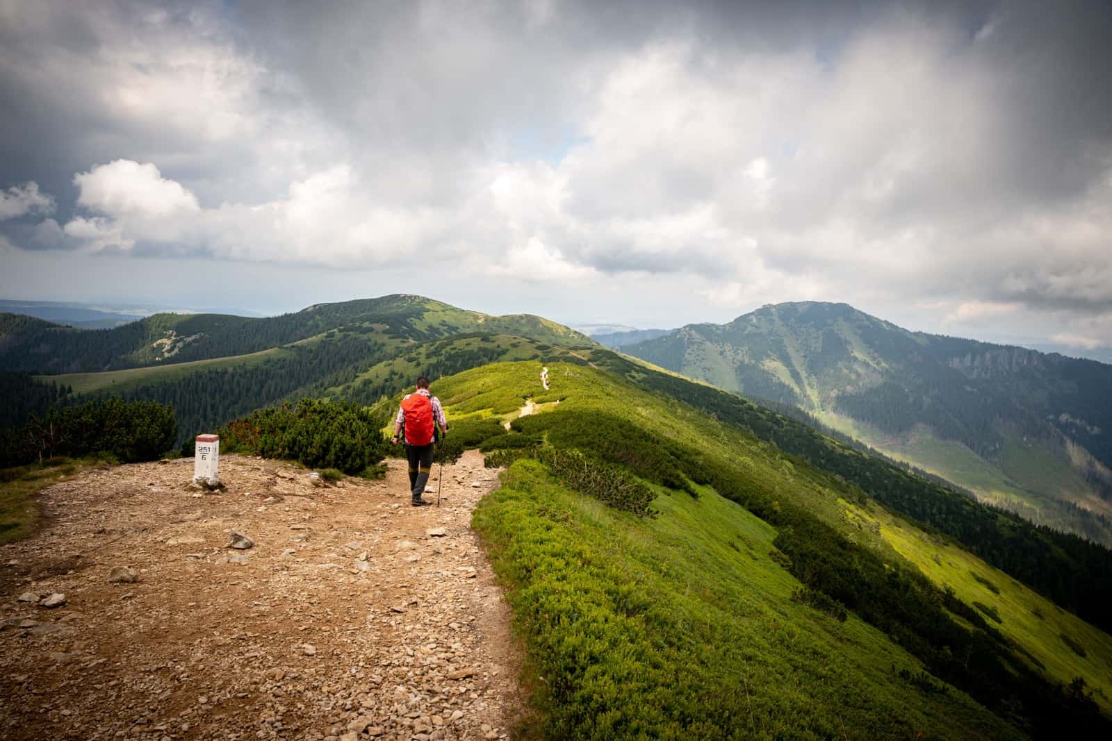 A hiker with a backpack on a mountain trail