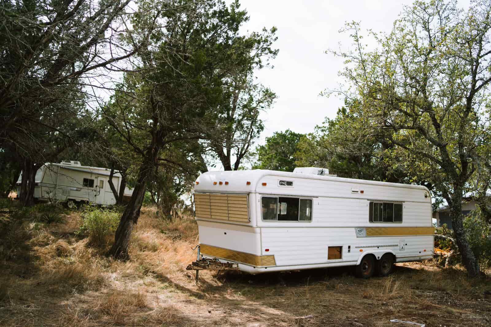 Vintage camper trailers parked among trees