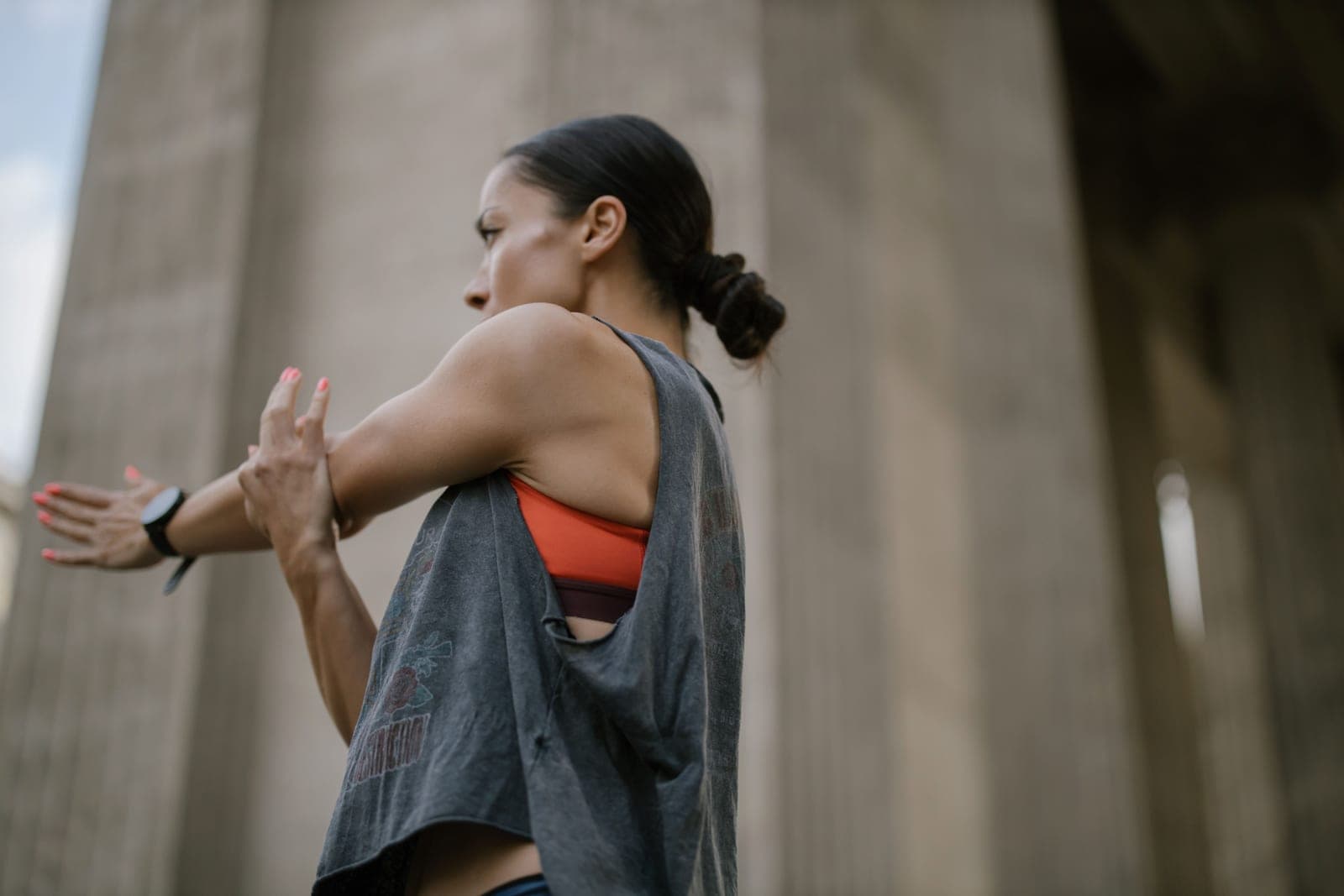 A woman in athletic wear stretching outdoors