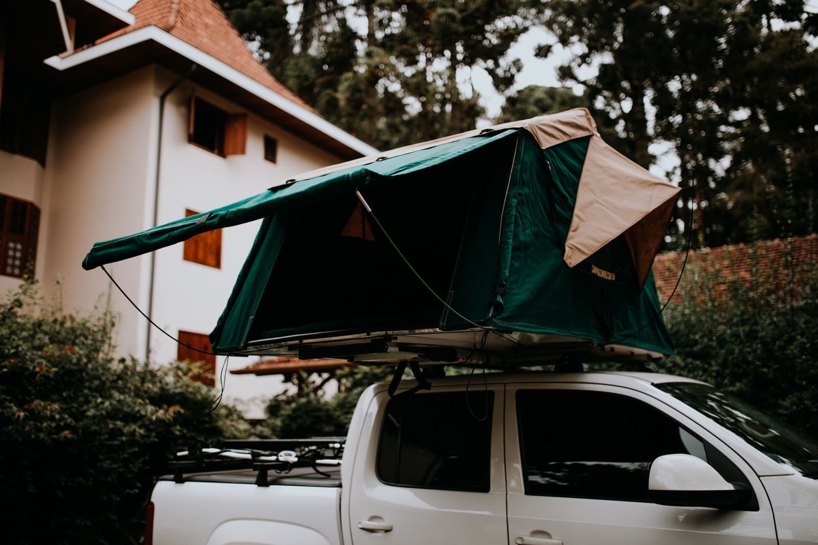 A rooftop tent set up on a white pickup truck